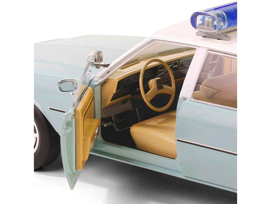 Light green diecast police car with white top, open front door showing tan interior