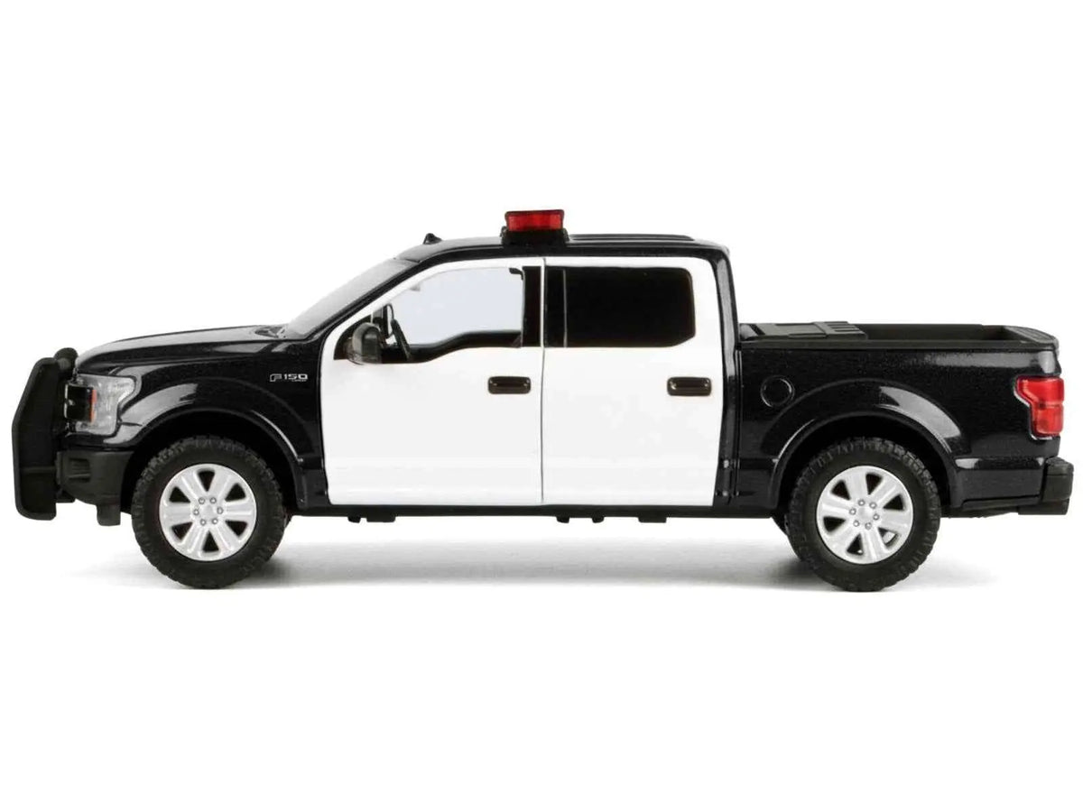 Black and white diecast pickup model side view with roof light bar and rear lights