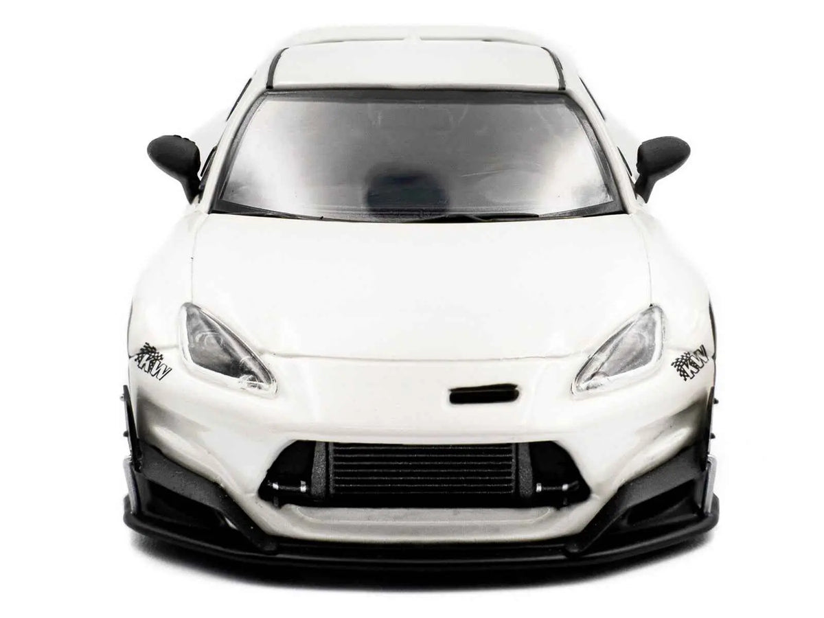 White diecast sports car model, front view with headlights and black grille accents