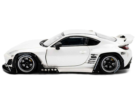White diecast sports car model with black wheels, side vents, and racing decals