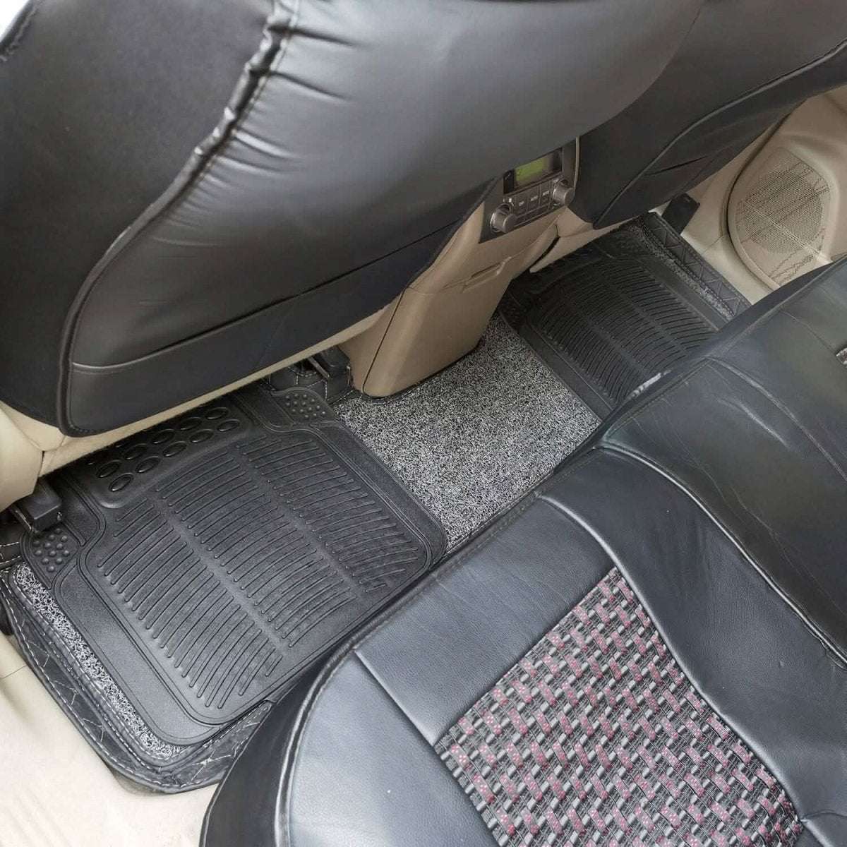 Black automotive floor mats with ribbed texture, raised border, and grip nubs in footwell
