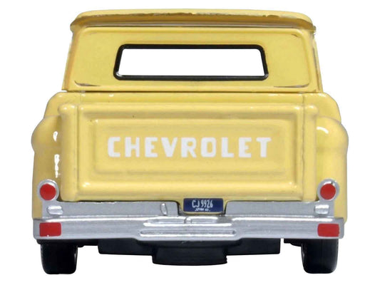 Yellow pickup truck diecast model, rear view with CHEVROLET tailgate lettering