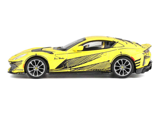 Side view of yellow Ferrari 812 diecast car with black stripe graphics and silver wheels