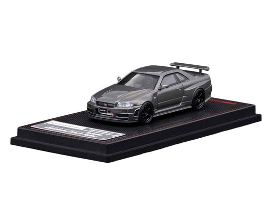 Gray 1/64 diecast Nissan Skyline GT-R model car, front 3/4 view, on black base