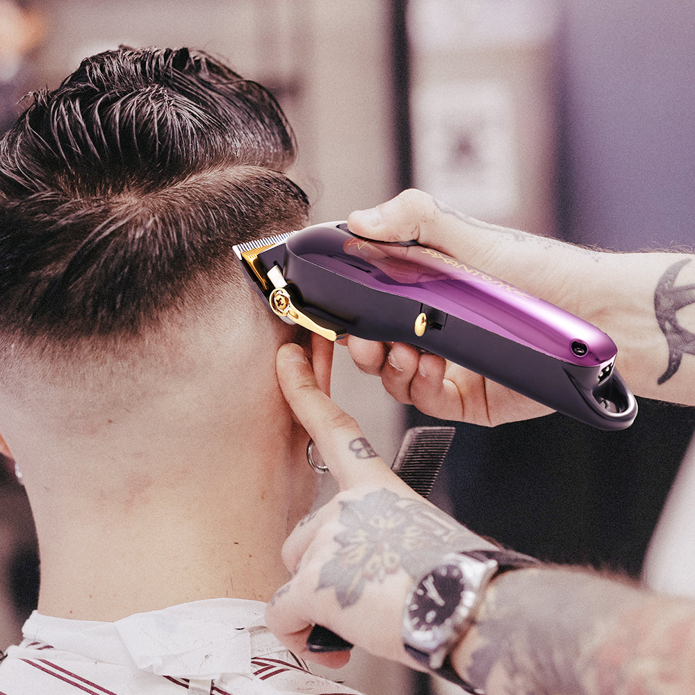 Purple professional hair clipper held at the side for trimming hair