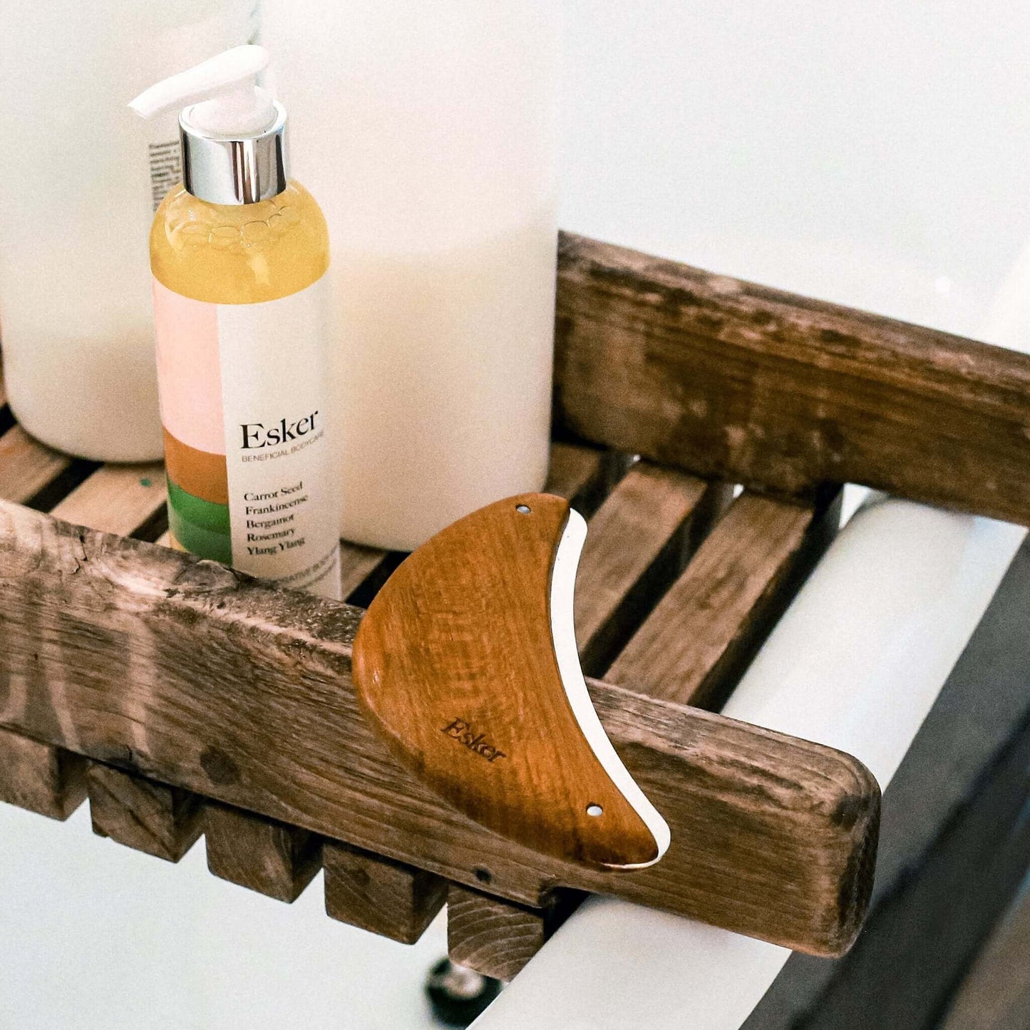 Curved wooden exfoliator tool resting on wooden rack