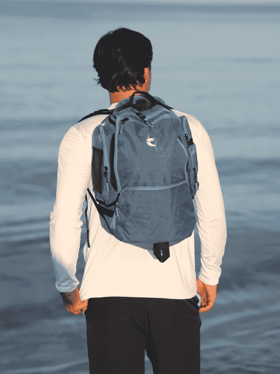 Blue day trip backpack on back with padded straps and top grab handle