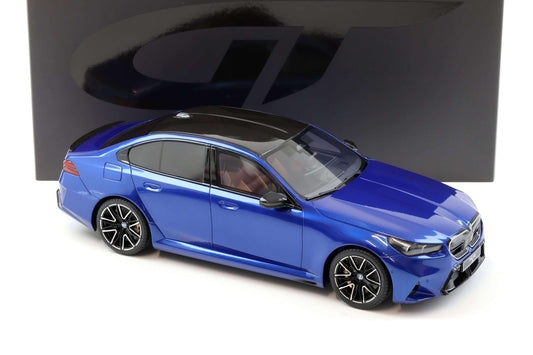 Metallic blue die-cast sedan model, side front angle, black wheels and headlights.