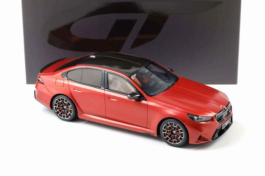 Die-cast BMW M5 model car in matte frozen orange, side three-quarter view