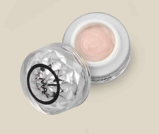 Eye cream jar opened, showing pink cream in a faceted clear container with white rim