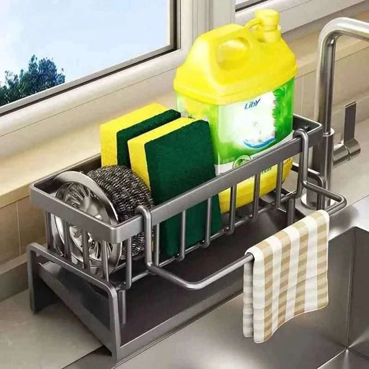 Gray sink organizer rack with raised rails, drainer basket, and hanging towel bar