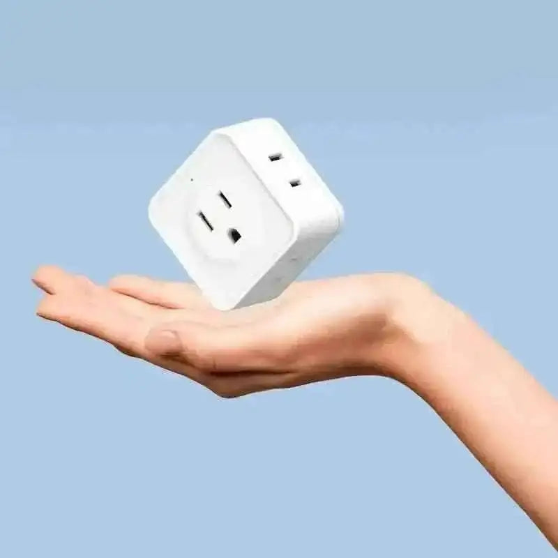 Five-way outlet extender plug held in hand, white with power socket and outlets.