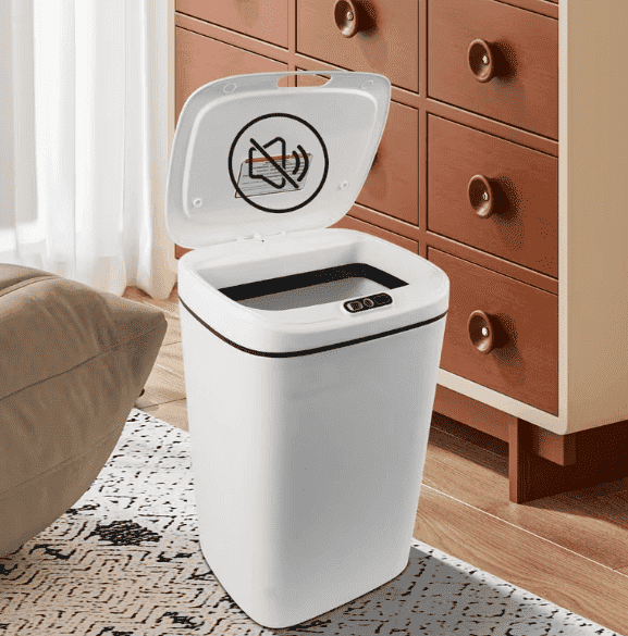 Cream white smart trash can with open lid on the floor near cabinets