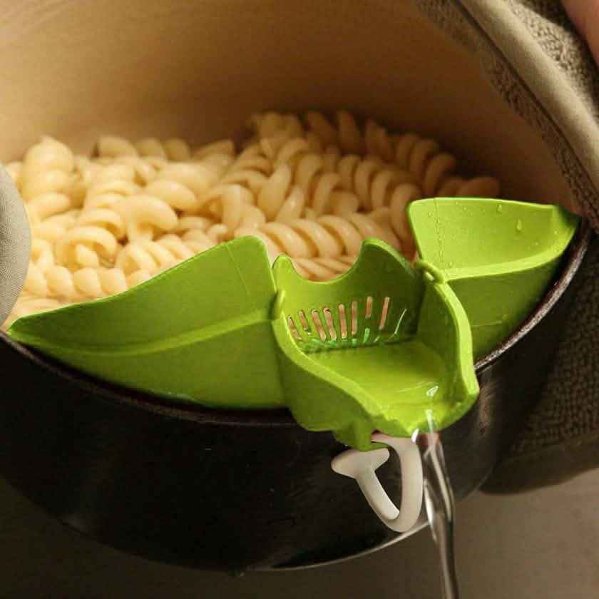 Green kitchen strainer insert with handle over a pot for draining
