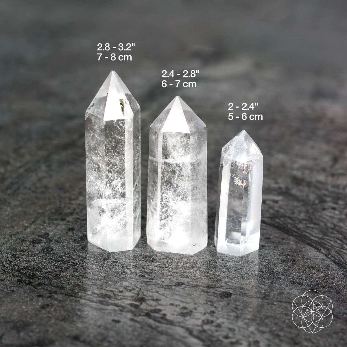 Three clear quartz intention stone points showing small, medium, and large sizes