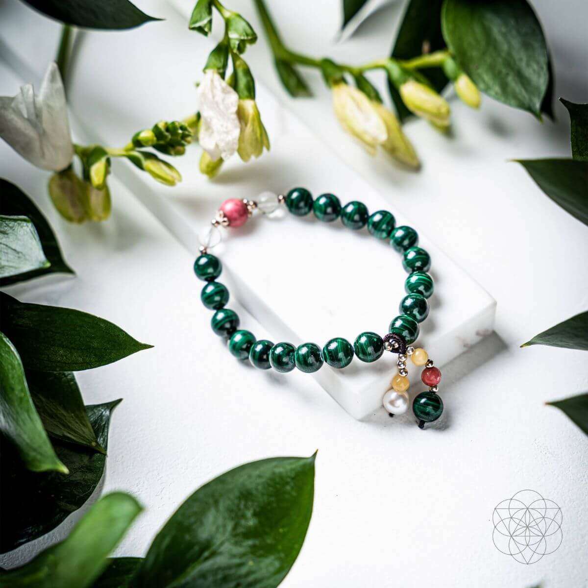Green beaded law of attraction bracelet with white and pink bead charms