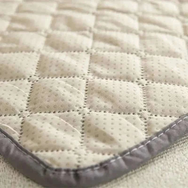 Pet bed cover, cream textured quilt with gray edge trim close-up.