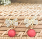 Rhinestone gold-tone bow ornament with two red ball drops and dangling hooks