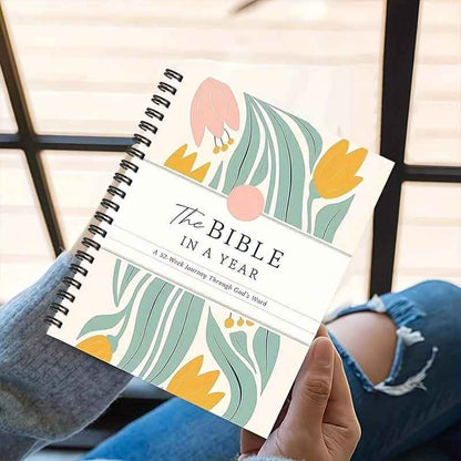 Undated spiral Bible study journal with botanical cover and “The Bible in a Year” in hand