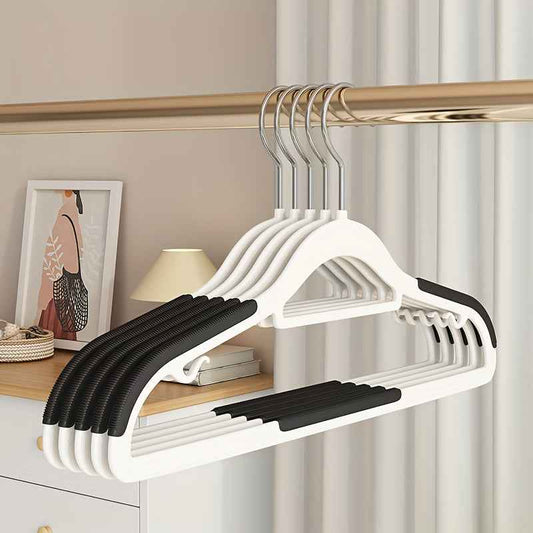 Plastic anti-skid clothes hangers, white with black grip bar, on closet rod