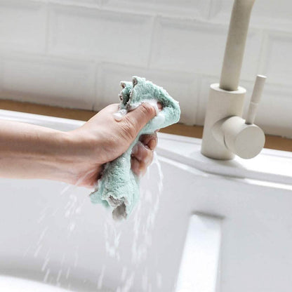 Dish towel wrung out under the faucet, teal cloth held in one hand