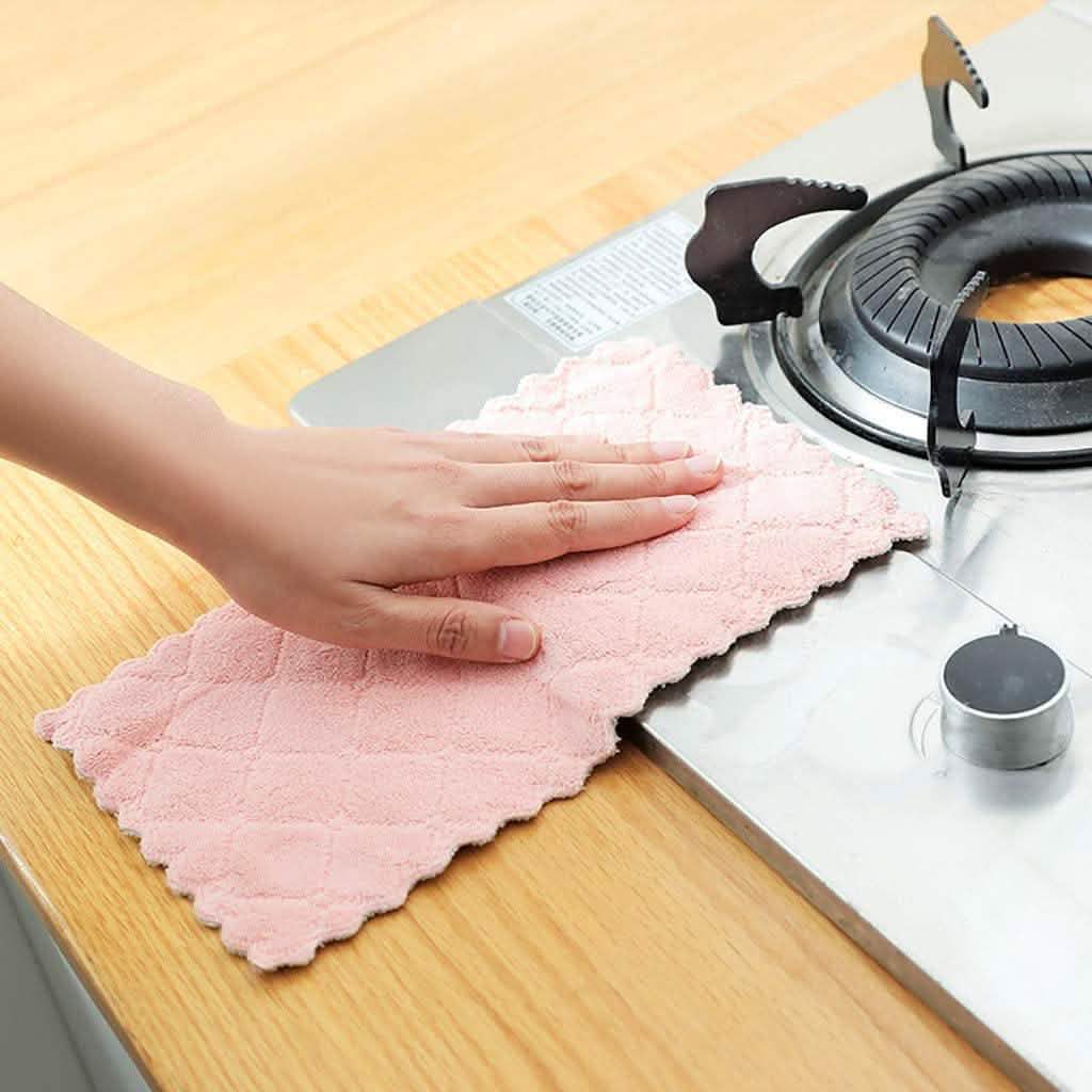 Kitchen dish towel, pink, wiping a white countertop near a kettle