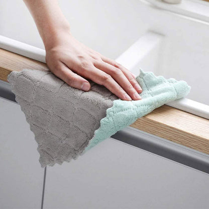 Gray and teal dish towels wiping a countertop edge, textured terry fabric