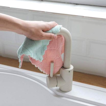 Kitchen dish towels: mint green and pink on a sink ledge near a faucet