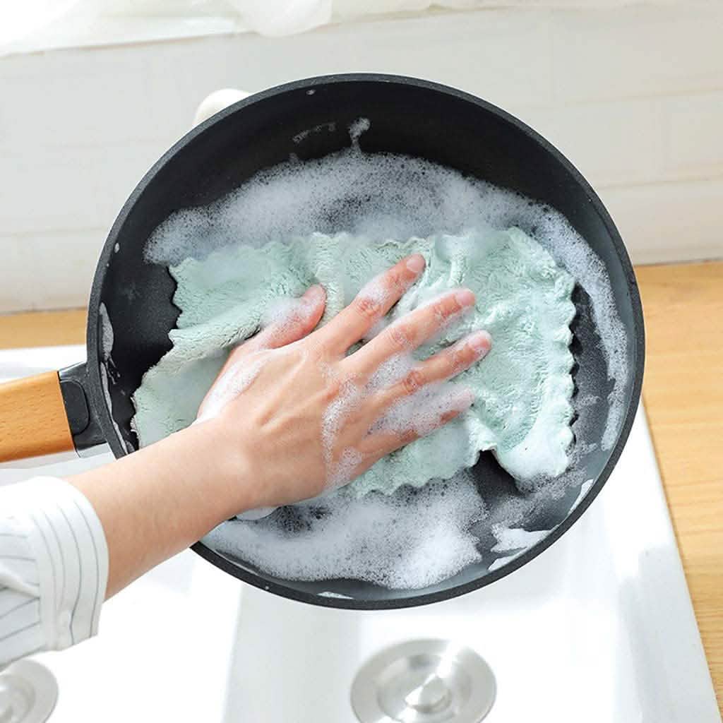 Dish towel scrubbing a frying pan with soapy suds, teal cloth in use