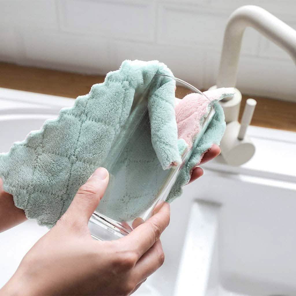 Teal and pink dish towels held together above the sink in hands