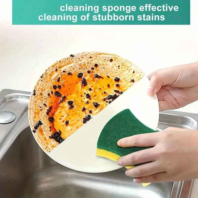 Kitchen cleaning sponge held on plate, green scrub top with yellow foam underside.