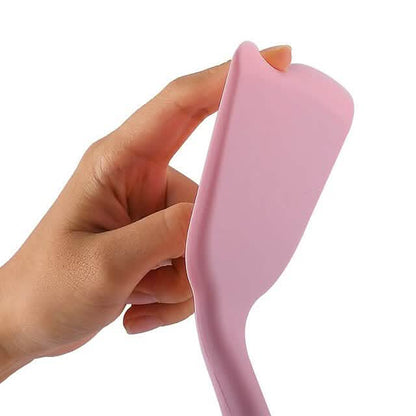 Pink silicone spatula with wooden handle held in hand