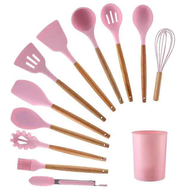 Pink silicone kitchen utensil set with wood handles, including spatulas and whisk