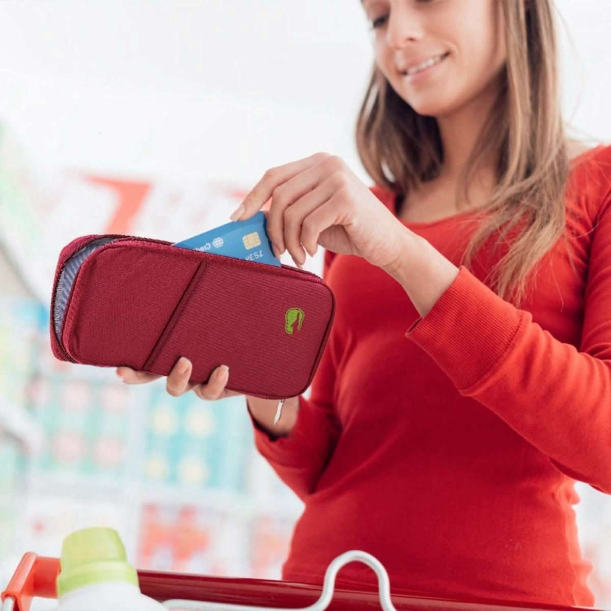Maroon passport wallet with zip closure, holding bank cards and a folded passport.