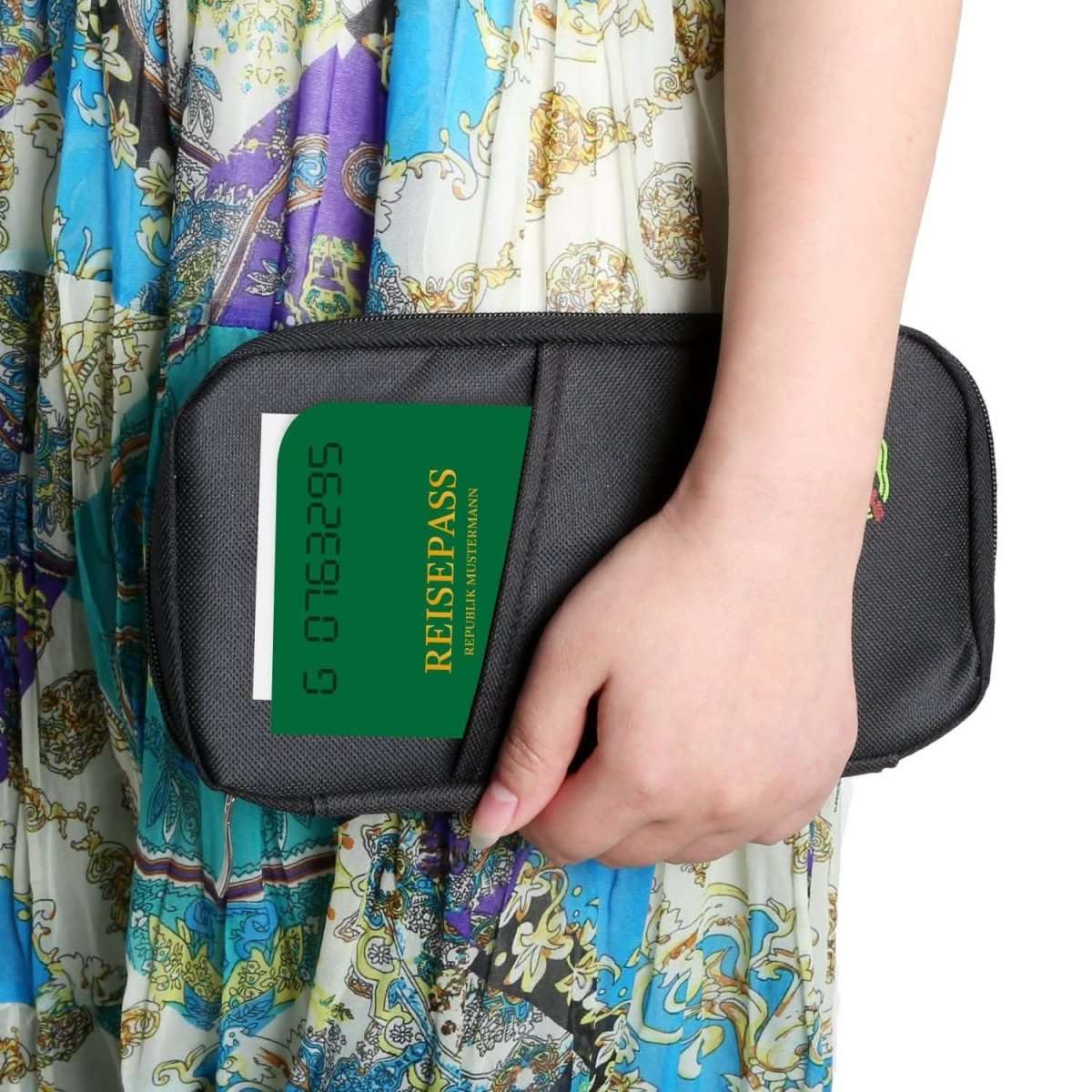 Black passport wallet held in hand, showing a green passport card sleeve and zip.