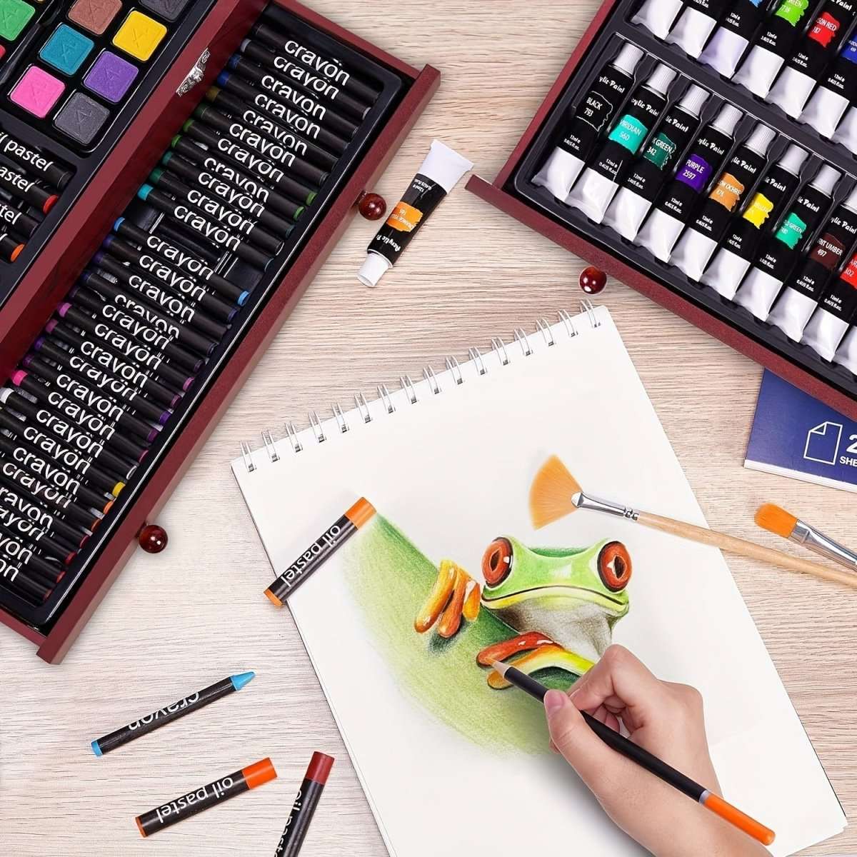 Art drawing pad with frog sketch, colored pencils, crayons, and paint tubes in cases