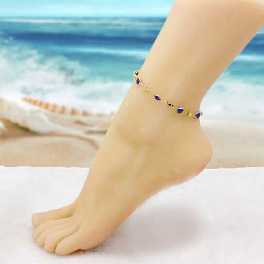 Gold-tone blue crystal ankle bracelet worn on the foot