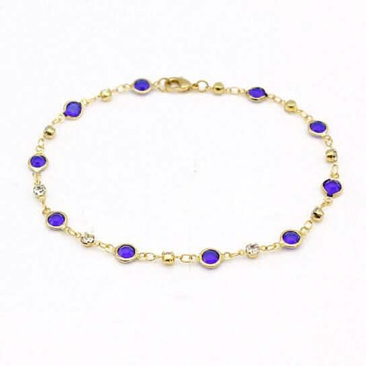 Gold-tone ankle bracelet with blue crystal links on a fine chain
