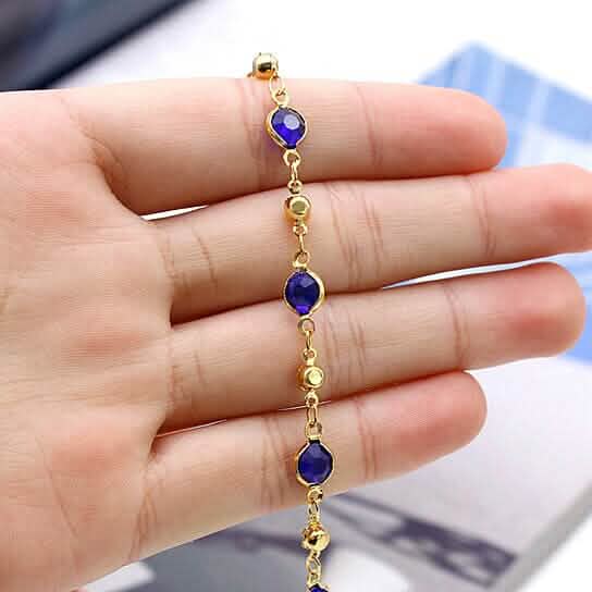 Gold-tone ankle bracelet with blue crystal charms on linked gold chain
