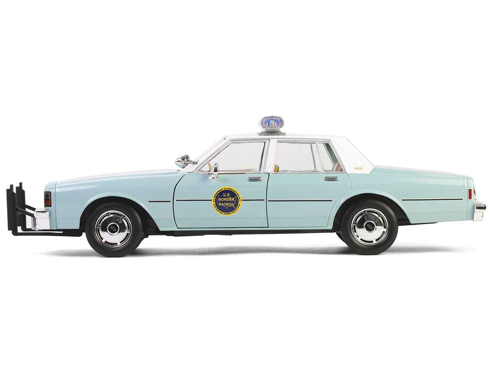 Side view of light green 1:18 diecast police sedan with white top and roof lightbar