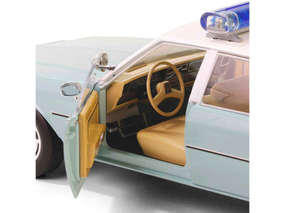 Light green diecast police car with white top, open front door showing tan interior
