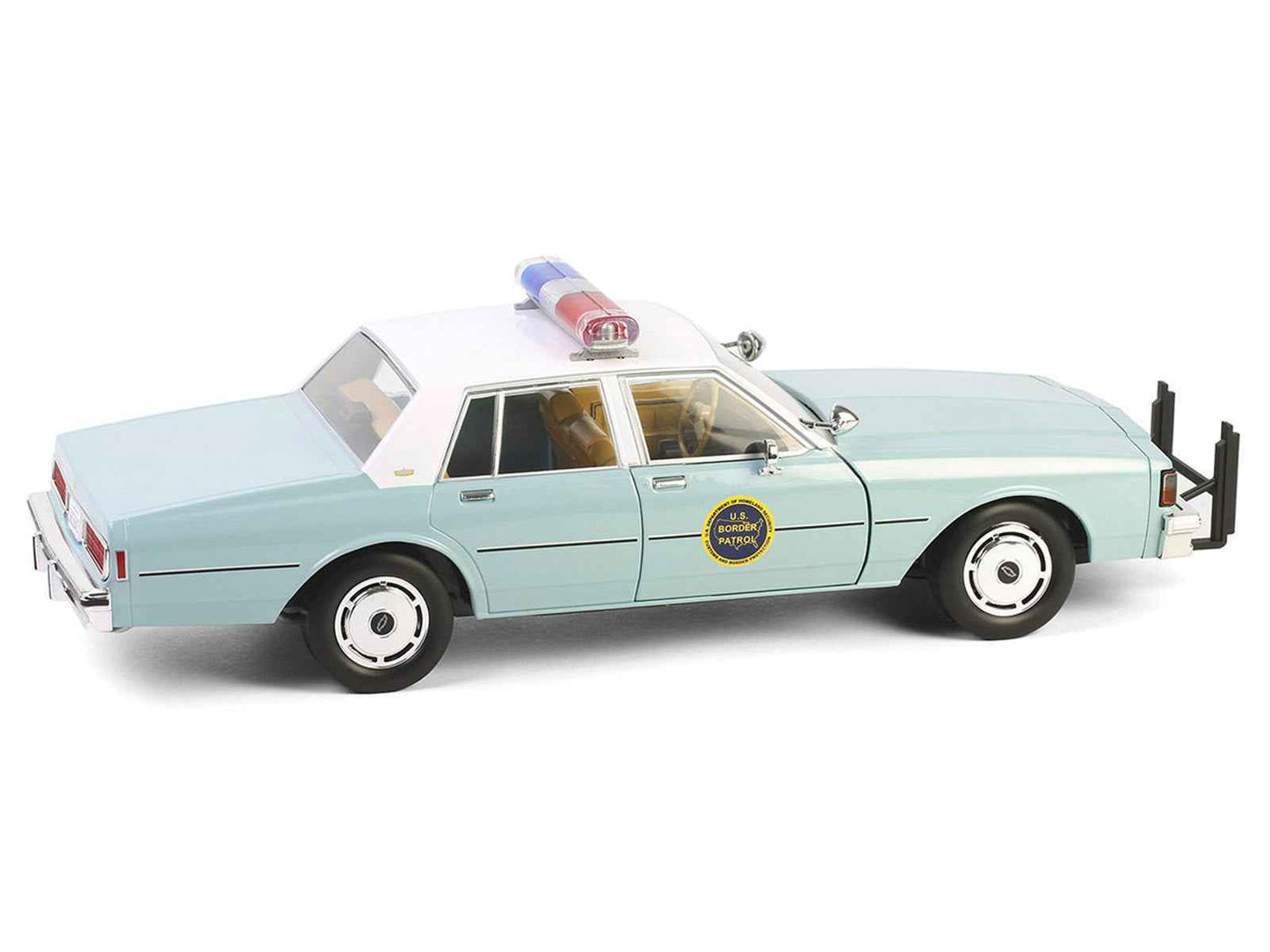 Angled view of light green 1:18 diecast police sedan with white top and front push bar