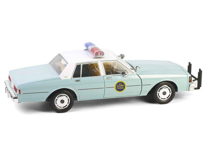 Angled view of light green 1:18 diecast police sedan with white top and front push bar