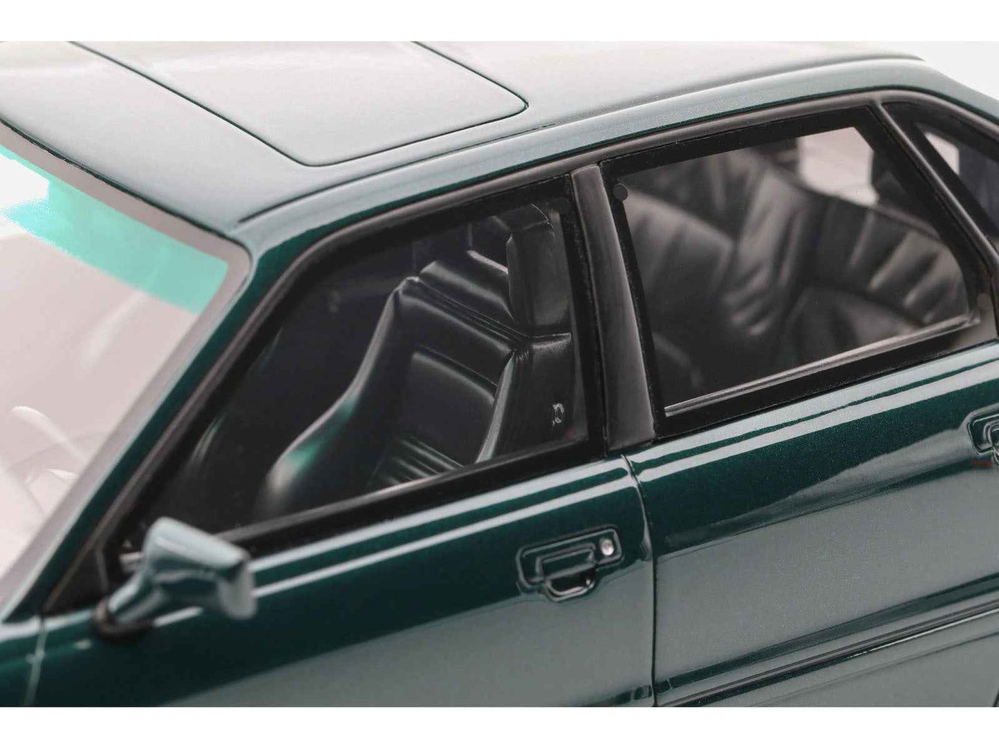 Emerald green metallic die-cast model car with door, window, and dark interior seats