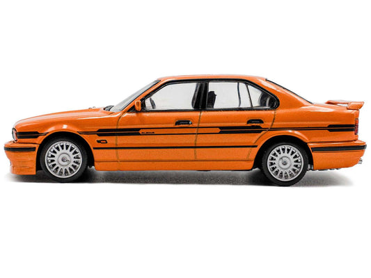 Orange diecast BMW sedan with black stripes, front-left side view, 1:43 scale.