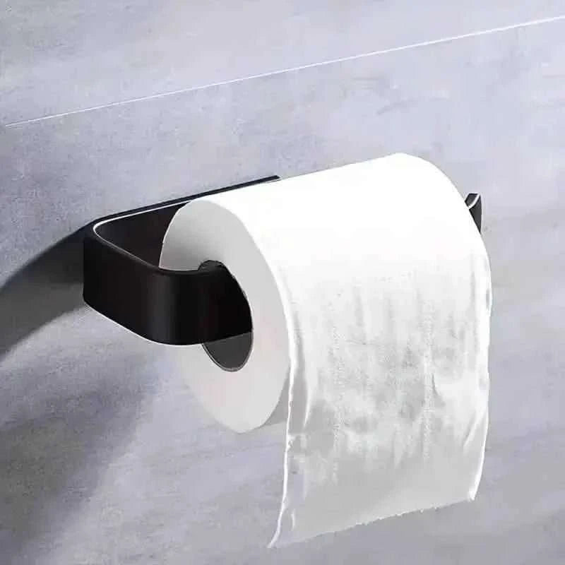 Black curved toilet paper holder with toilet paper roll mounted on wall.