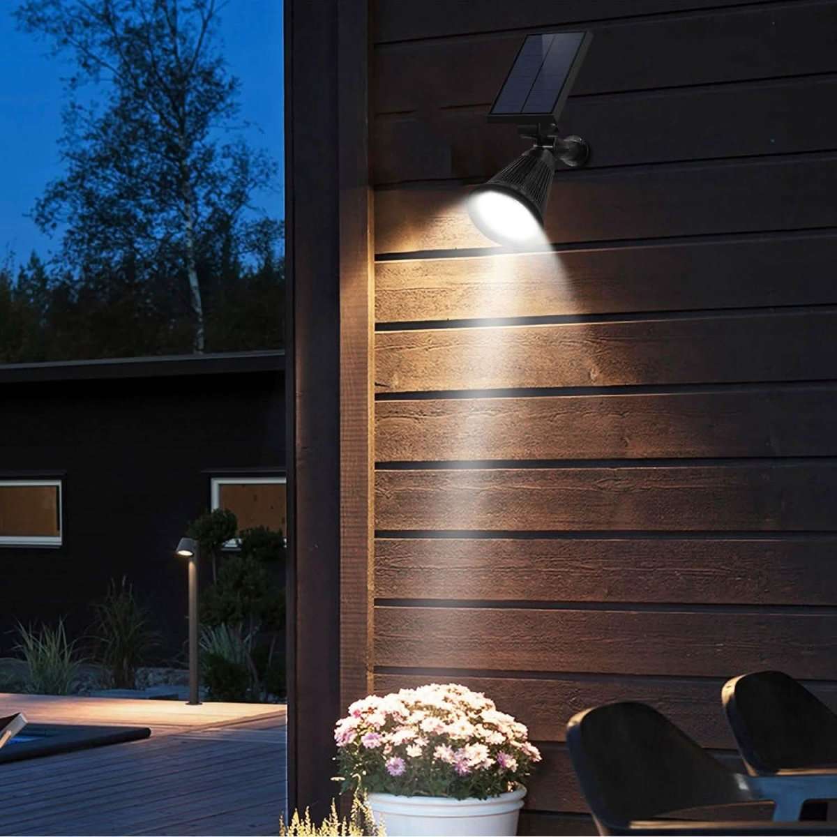 Solar spotlight mounted on an exterior wooden wall with an angled round LED lamp