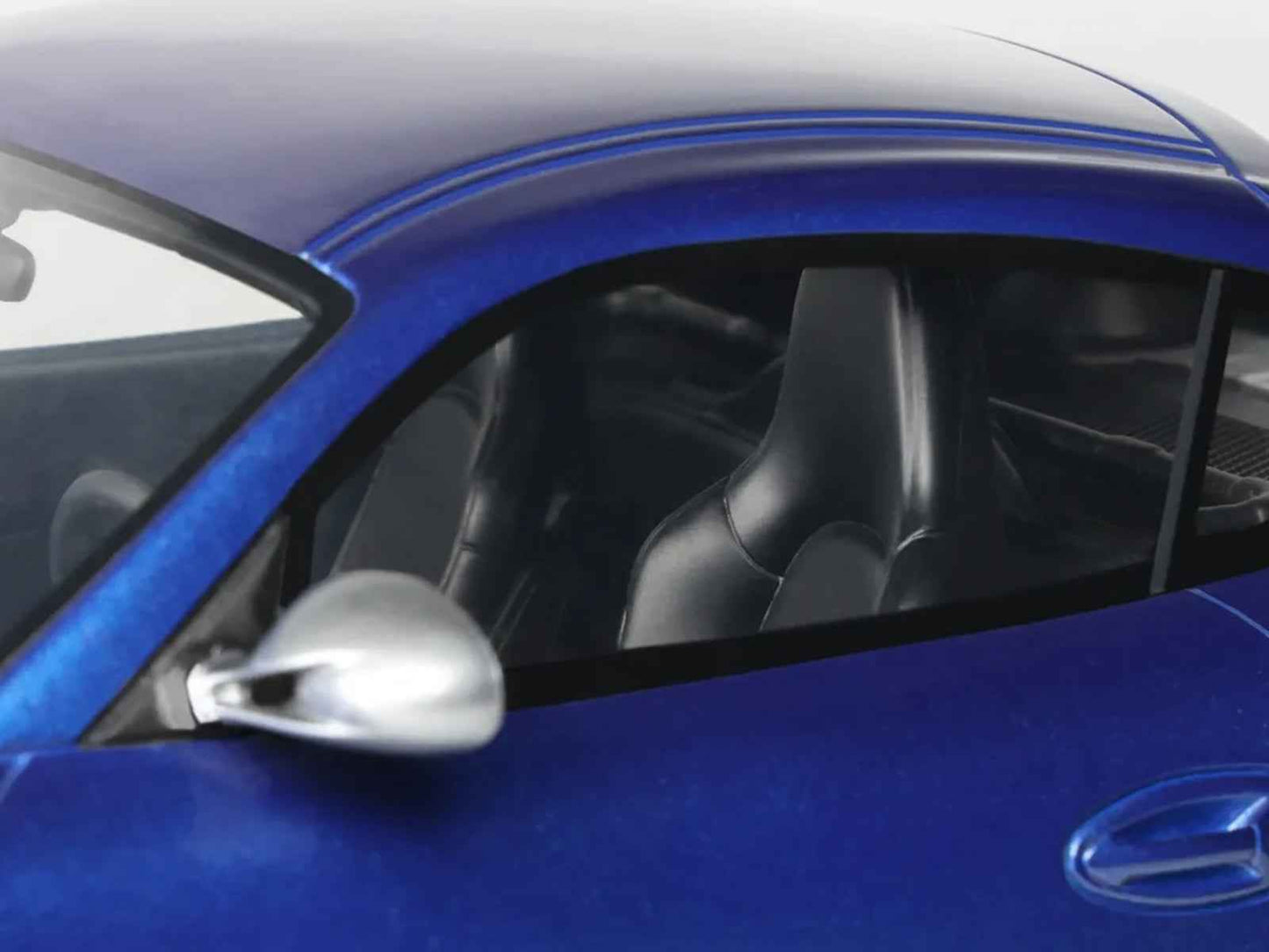 Blue Porsche Cayman R 1/18 die-cast model interior, steering wheel and dashboard close-up