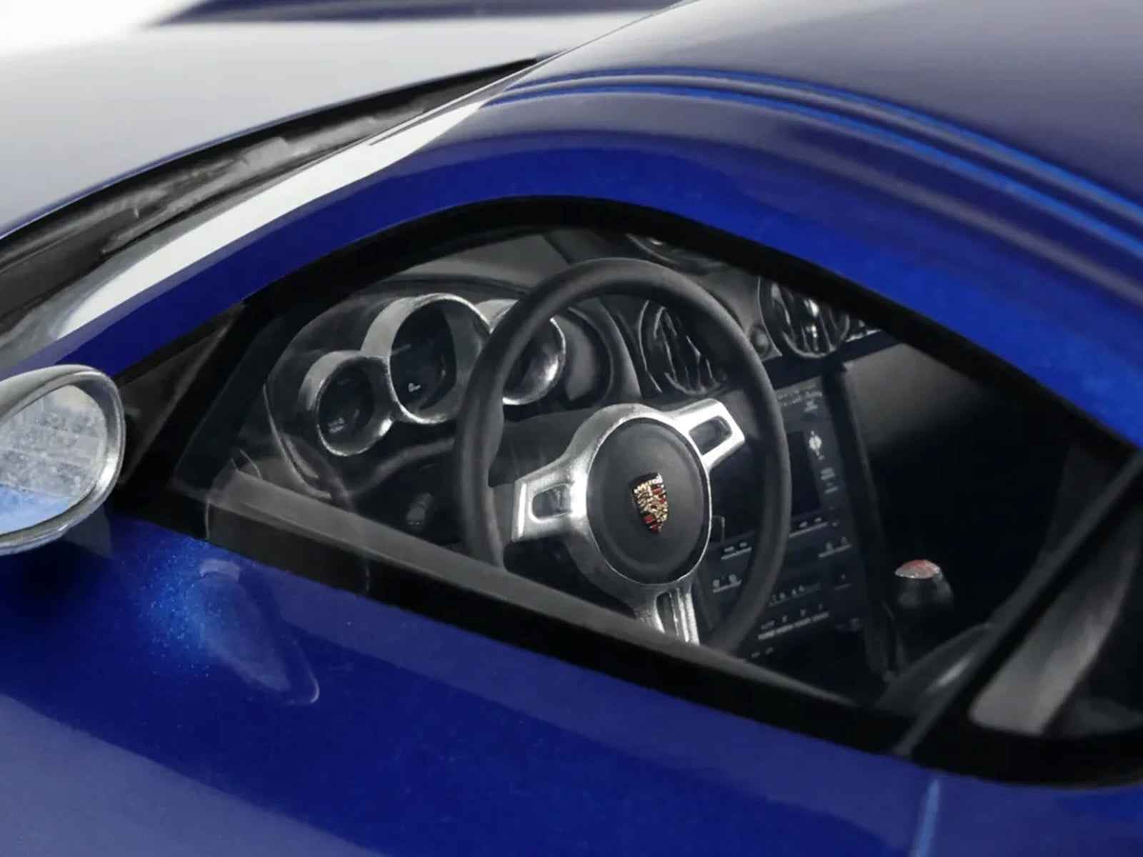 Blue Porsche Cayman R 1/18 model car, front three-quarter view with white stripes