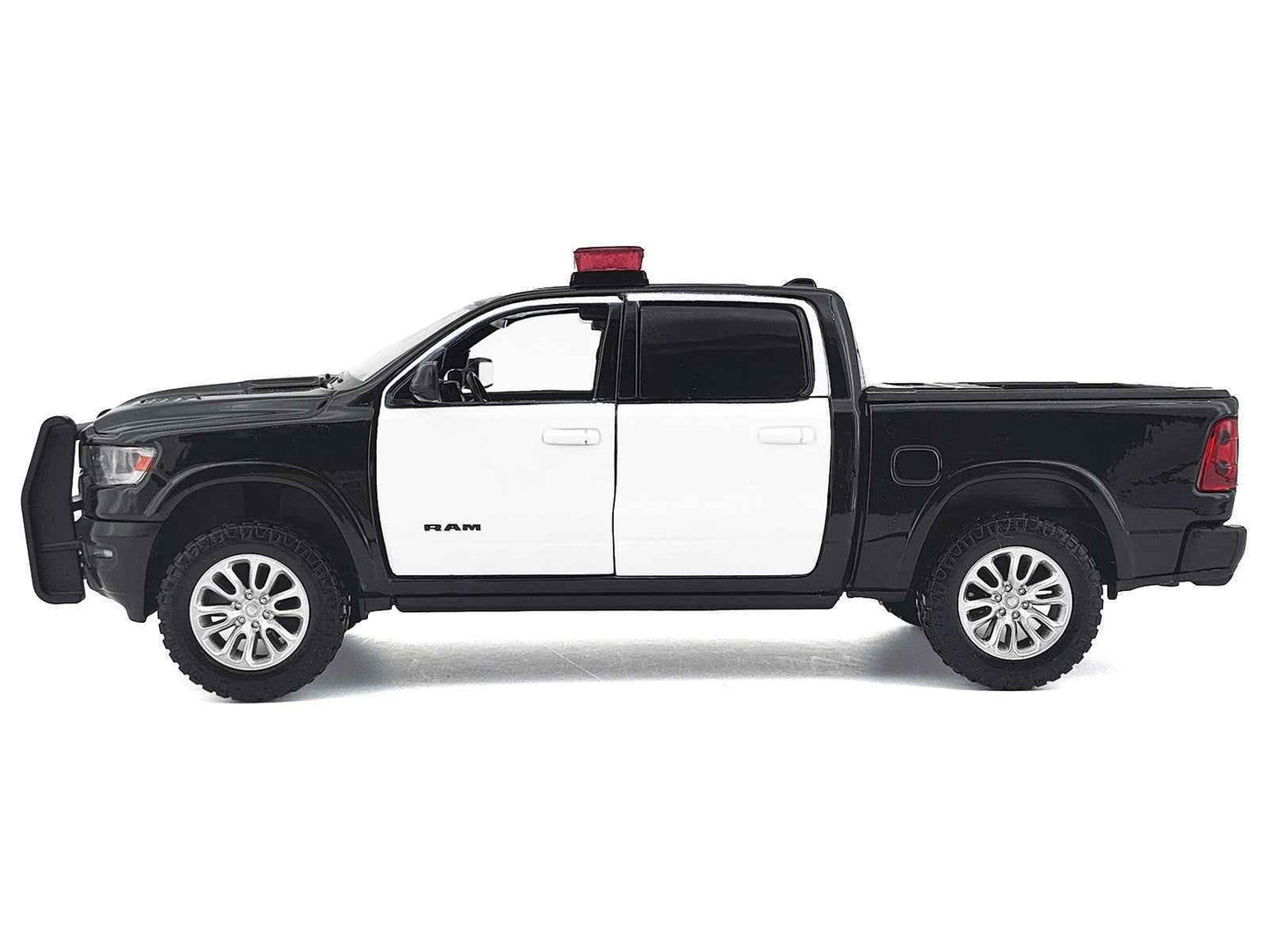 Black and white 1:27 scale diecast pickup truck side view with roof light bar